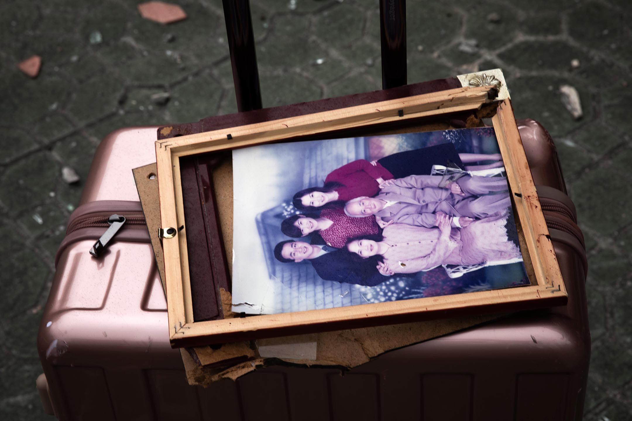 2024年4月5日，居民被迫撤離大廈，行李上有一幅家庭照。攝：陳焯煇/端傳媒