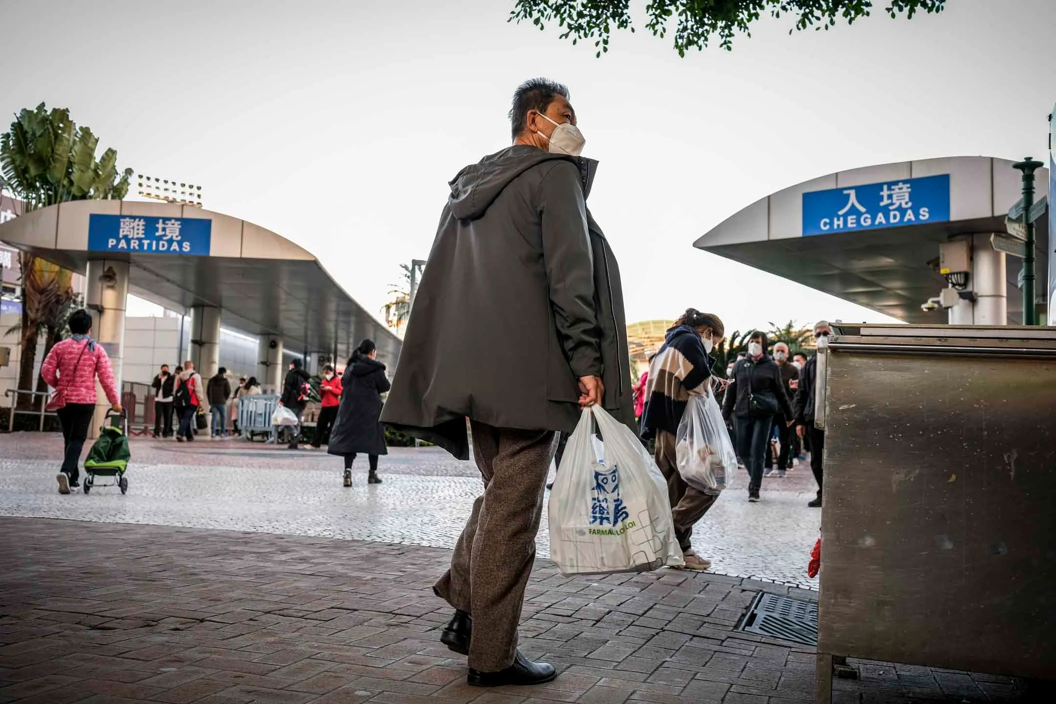 關閘前，一名男子提着藥房袋子。