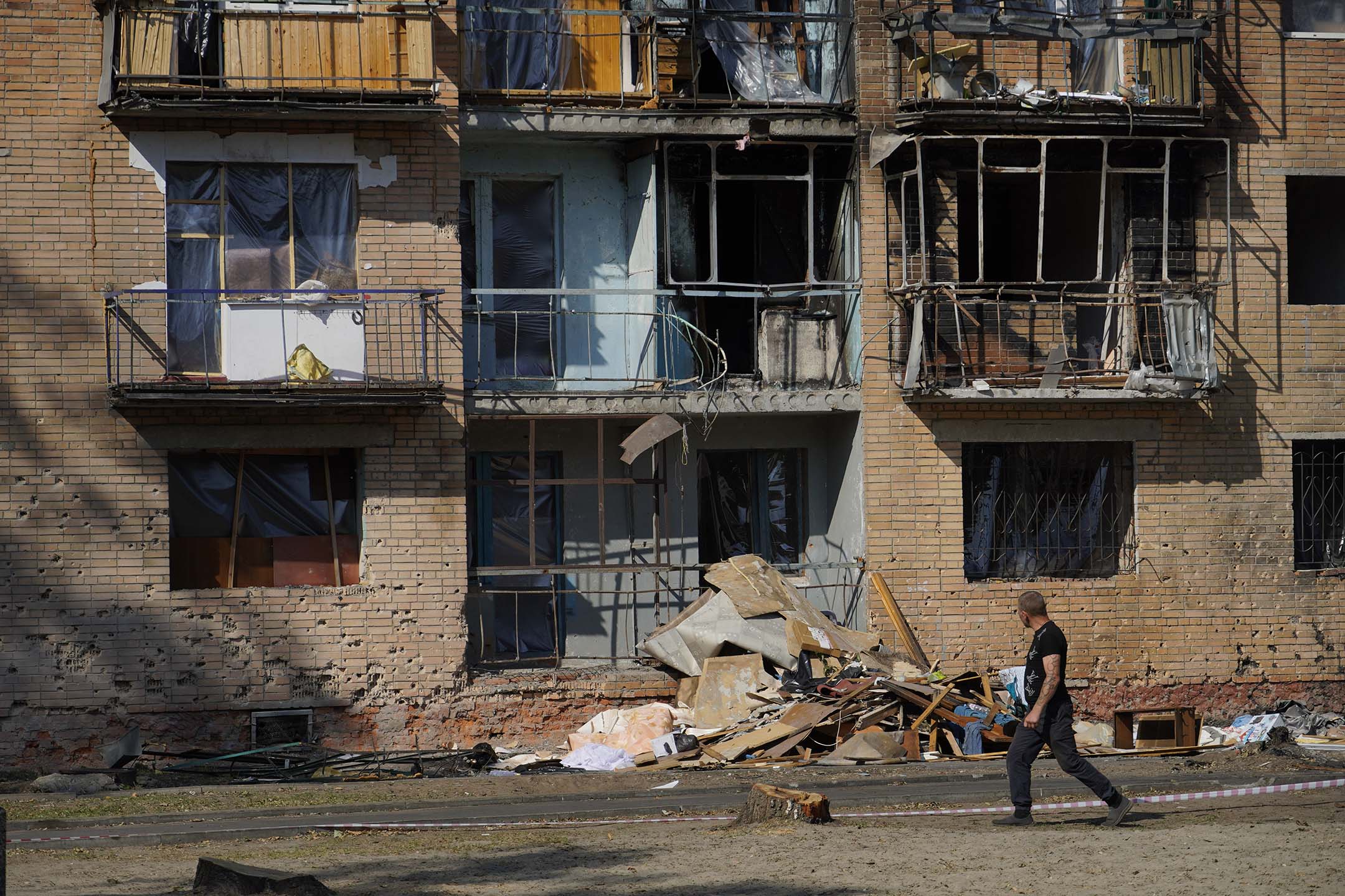 2024年8月19日，俄罗斯库尔斯克，一名男生经过受破坏的大楼。摄：Vladimir Aleksandrov/Anadolu via Getty Images