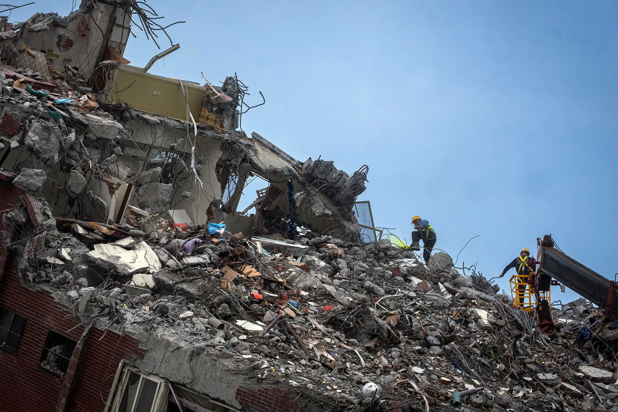 2024年4月13日，花蓮，工程人員在天王星大樓上嘗試帶走倒塌房子内的貓。攝：陳焯煇/端傳媒