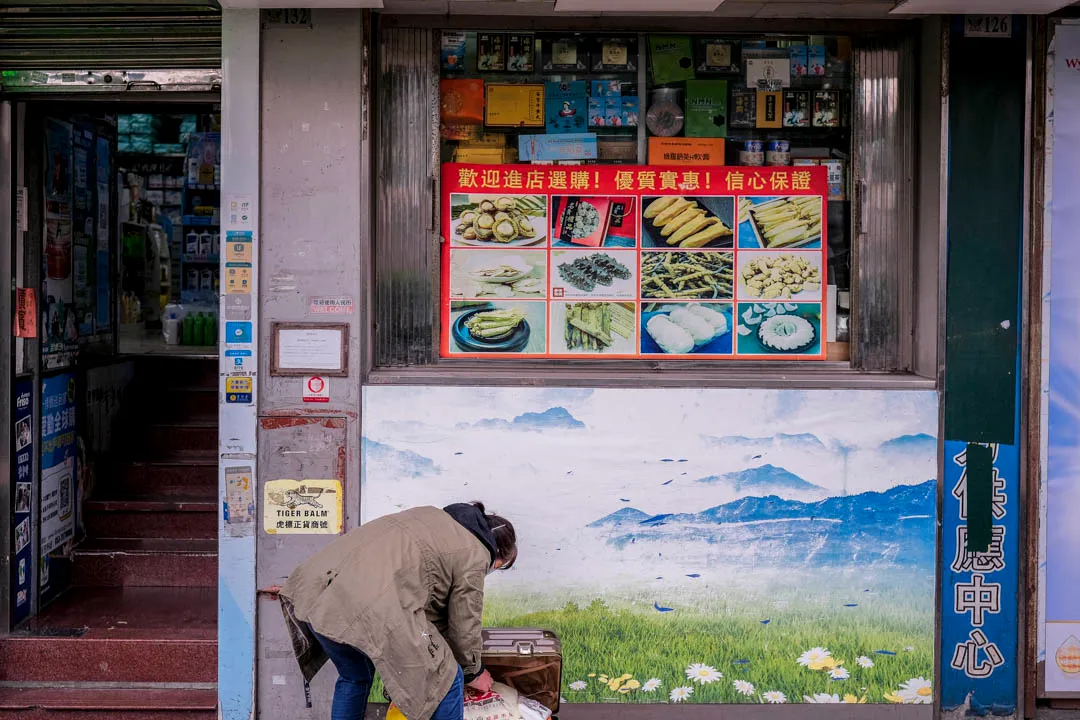 一名女子於藥房購物後於店外入箱。